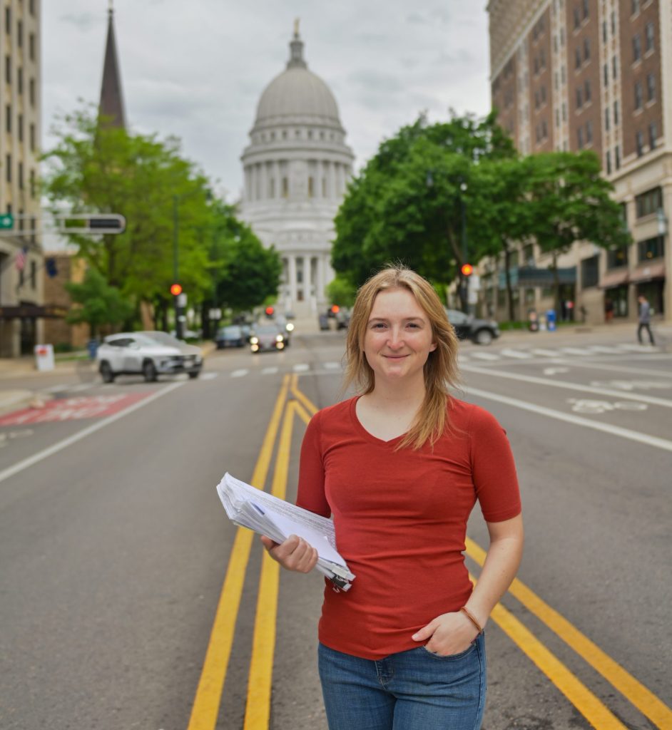 woman standing in front of the Madison, WI capitol building.